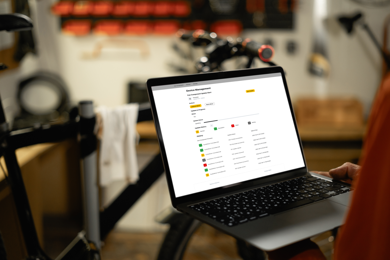 Offener Laptop mit Device, im Hintergrund ein CYCLE E-Bike